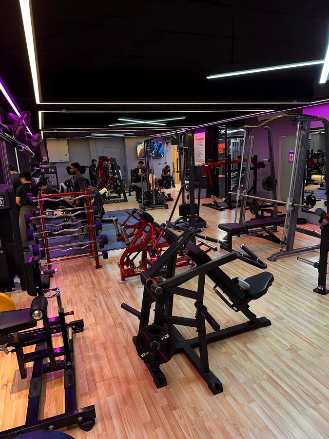 Plate-loaded strength machines with red and black frames at Shredded Fitness