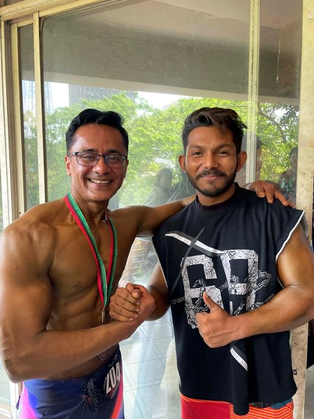 Two members posing on the gym floor